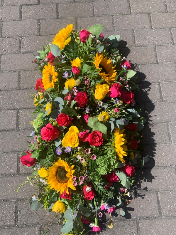 Bright garden style casket tribute