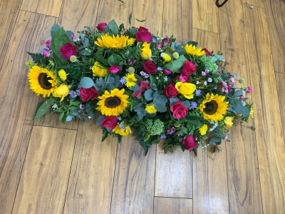 Bright garden style casket tribute